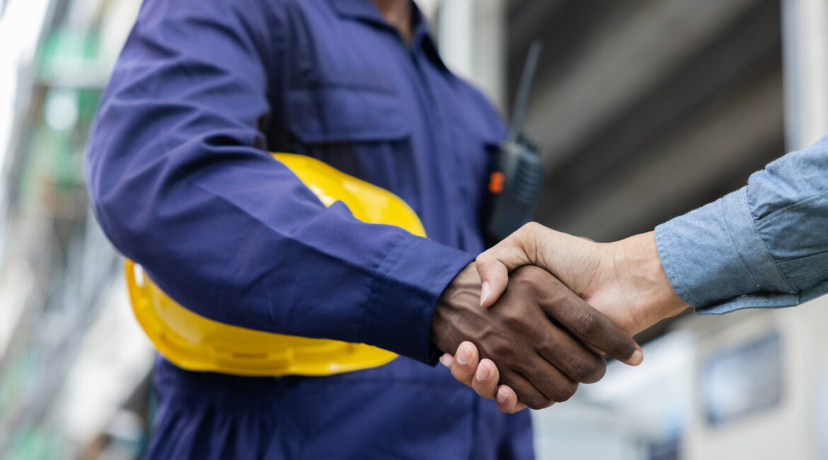 Construction Company Partners Obtain Loan to Complete a Management Buyout 1 Construction workers shaking hands together